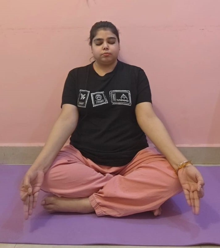girl is meditating peacefully on purple color yoga mat